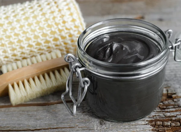 Black volcanic cosmetic clay in a glass jar — Stock Photo, Image