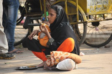 Hintli anne bebeği ile sadaka isteyen