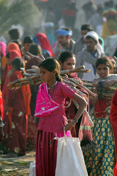 India niñas caminando en Pushkar Camel feria sosteniendo bolsas, a través de la gente —  Fotos de Stock