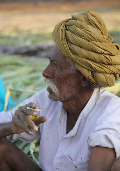 Hombre indio con turbante verde fumando un cigarrillo — Foto de Stock