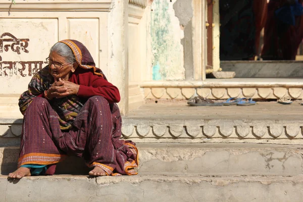 Oude Indiase vrouw zitten buiten een tempel — Stockfoto