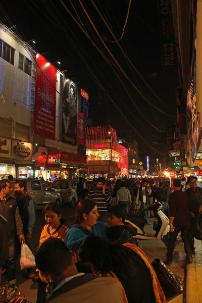 New Delhi by Night. Vista notturna di una via dello shopping illuminata da persone che camminano tutto intorno — Foto Stock