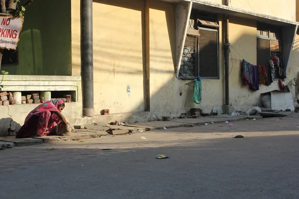 Zavallı Hintli kadın oturup harap bir stree — Stok fotoğraf