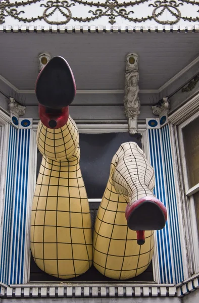 Gambe grandi con calze a rete appese fuori dalla finestra — Foto Stock