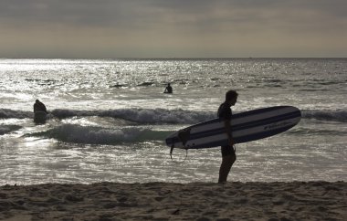 Sörfçü San Diego Mission Beach shoreline üzerinde