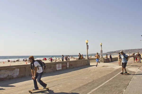 Променад на пляже Сан-Диего с парнем на скейтборде — стоковое фото