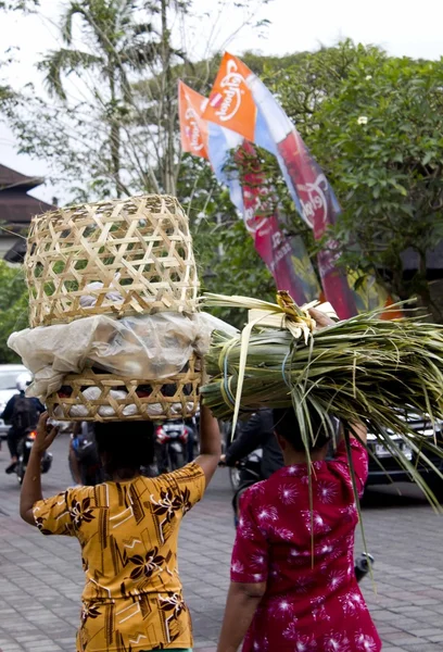 Two balinese woman from the backside carrying baskets on their heads — Stok fotoğraf