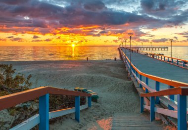 Colorful sunset at a famous marine pier in the Baltic Sea clipart