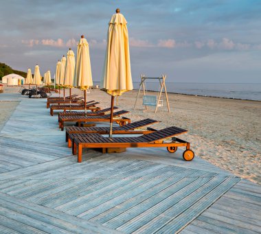 Baltık Denizi 'nin kumlu sahilinde ahşap güverte sandalyeleri ve güneş gözlükleriyle dinlenme yeri.