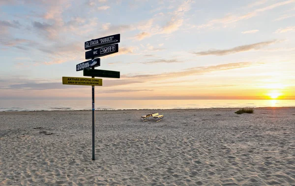 背後の砂浜に看板のある木製の看板 — ストック写真