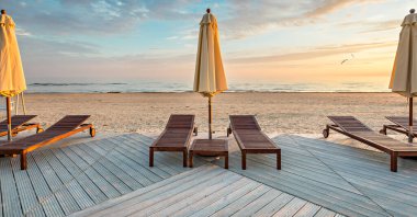 Baltık Denizi 'nin kumlu sahilinde boş iskemle ve güneş gözlükleriyle dinlenme yeri. 