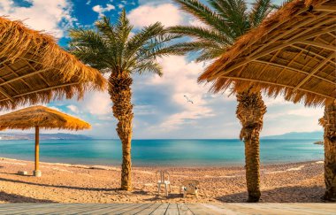 Panorama. Eilat 'ın ahşap zeminli kumlu sahili. İsrail' in ünlü turistik beldesi ve eğlence merkezi.