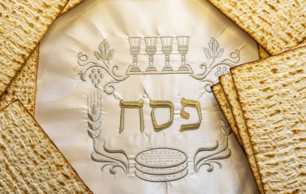 Pesah celebration concept - Jewish Passover holiday Unleavened bread food - matzoh . White napkin with three Hebrew letters, in English translation mean Jewish Passover