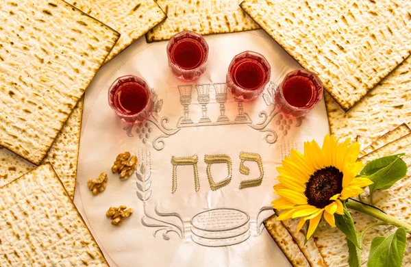 Pesah celebration concept - Jewish Passover holiday. Unleavened bread food matzoh, glasses of red wine, walnuts and sunflower. Three Hebrew letters, in English translation mean Jewish Passover