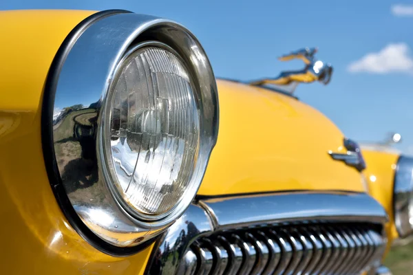 Detalj av en gul vintage bil på en bakgrund av himlen. (Ident — Stockfoto
