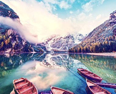 Güney Tyrol, Alpler, İtalya ve Avrupa 'daki Dolomitler' deki Fanes-Sennes-Braies doğal parkındaki gölde teknelerle büyüleyici bir sonbahar manzarası. Egzotik, inanılmaz yerler. (uyum - kavram)