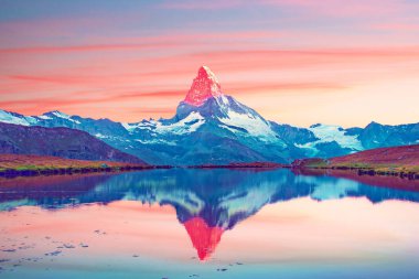 İsviçre 'nin Zermatt kenti yakınlarındaki İsviçre Alpleri ve Stellisee Gölü' nde sabah güneşi altında Matterhorn Dağı 'nın tepesinden aydınlatılan muhteşem manzara. Harika bir yer. (Uyum, meditasyon - kavram)