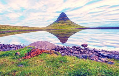 Büyüleyici bir manzara. Yanardağ Kirkjufell ile Snfellsnes Yarımadası 'nda. Gölün aynasında Grundarfjrur kasabası yakınlarında. Egzotik ülkeler. Harika yerler. Popüler turist akımı.