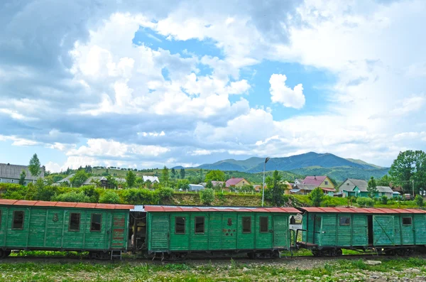 Régi vasúti kocsikat, a háttérben a hegyek — Stock Fotó