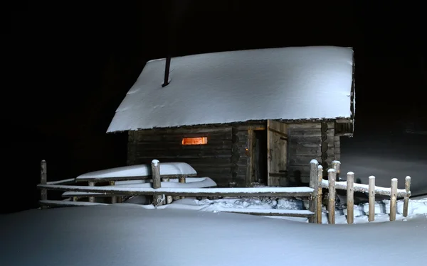 Winterlandschap met sneeuw bedekte hut in het bos in de moun — Stockfoto