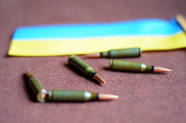 Bullets on a background Ukrainian flag (war in Ukraine, victims — Stock Photo, Image