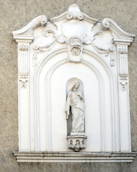 The facade of an old house with niche and sculpture of the Virgi — Stock Photo, Image