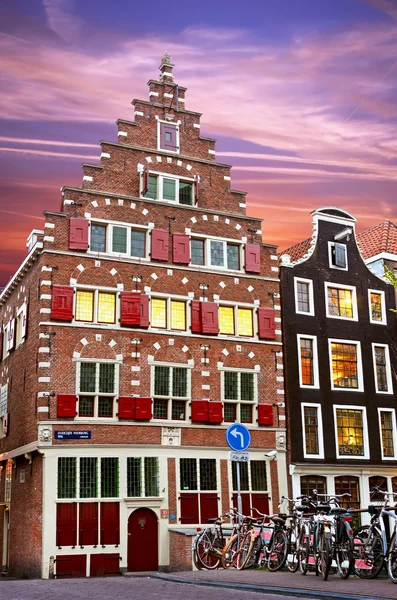 Fabulous ancient medieval houses in Amsterdam with shutters at dusk and bikes — Stockfoto