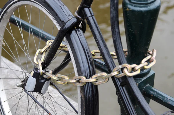 Fragmentet cykel närbild metalliskt kedja fäst till räcken i Am — Stockfoto