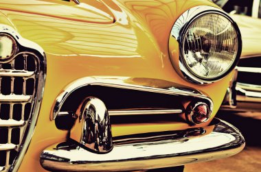 The hood, bumper, headlight and radiator of stylish yellow vinta