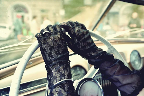 Women's hands in transparent gloves on the steering wheel of ret — Stock Photo, Image