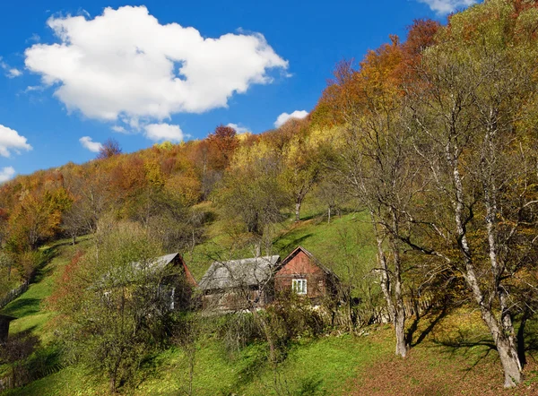 Paisaje místico con una cabaña en la colina en otoño en un backgro —  Fotos de Stock