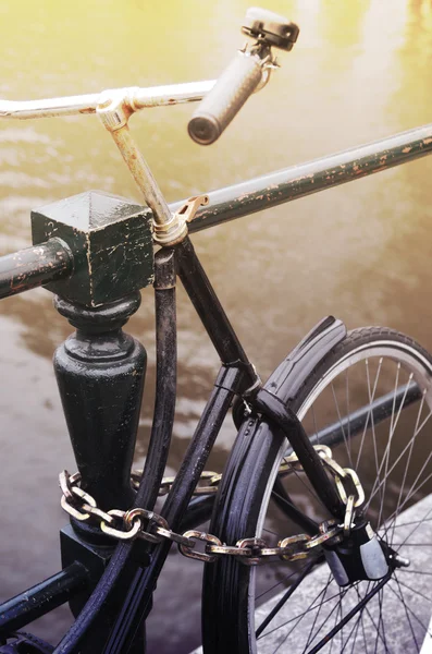 Fragmentet cykel närbild metalliskt kedja fäst till räcken i Am — Stockfoto