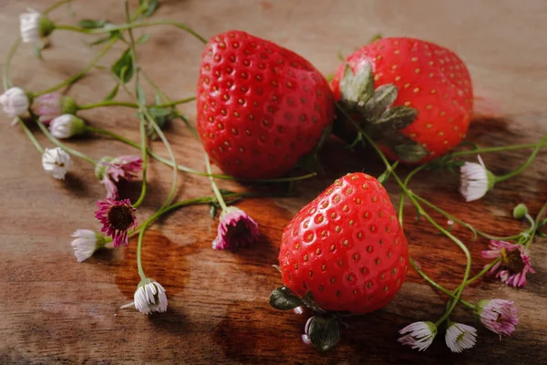 Strawberries and small wild flowers — Stock Photo, Image