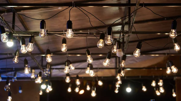 Bir sürü parlak ampul, odak noktasında manzara. Retro lamba dekorasyonu. Açık hava partisi konsepti