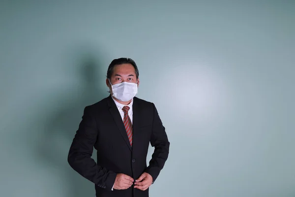 아시아 사업가가 수트를 의료용 마스크를 카메라를 모습은 복제품 공간을 코로나 — 스톡 사진