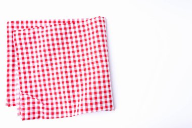 Masa örtüsü kırmızı ve beyaz kumaşlı pamuk beyaz bir masanın üzerinde katlanmış ve fotokopi alanı var. Restoranlarda yiyecek ve içecek menüleri tasarlamak için arka plan.