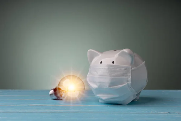 Piggy Bank Draagt Het Medisch Masker Met Gloeilamp Blauwe Houten — Stockfoto