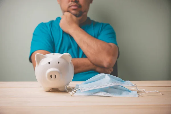 Een Witte Spaarpot Met Een Blauw Medisch Masker Een Houten — Stockfoto