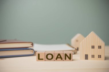 Ahşap bloklara kredi, rekor harcamalar için kitaplar ve eski ahşap masa yeşili arka plan ve fotokopi alanı. Konsept kredi satın alma evi, bankacılık, finans, muhasebe, sigorta.