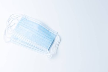 Üst görünüm mavi tıbbi maske, beyaz arka planda, kopyalama alanı var. Koronavirüsleri korumak için her zaman maske takan insanlar ve sosyal mesafeler için.. 