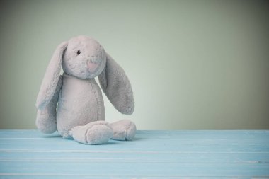 Büyük kulaklı tavşan bebek mavi ahşap masa ve fotokopi alanı. Tatlı oyuncak bebek tavşan hayvan ve çocuklar için tüylü kürk, bebeğim..