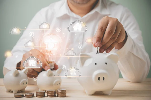 Kredi, muhasebe, finans ve bankacılık teknolojiyle internet ağı konseptini kullanıyor. Sanal bulut hesaplama teknolojisiyle ampul tutan bir iş adamı ve üç tane beyaz kumbara..