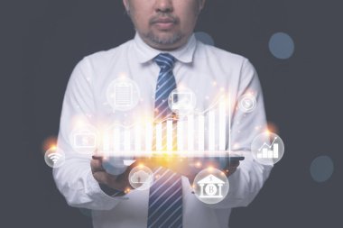 İnternette dijital pazarlama. İş adamı, iş stratejisini geleceğe planlamak için verileri büyüme grafiğiyle analiz ederek tablet kullanıyor. İş dünyası ve teknoloji kavramı.