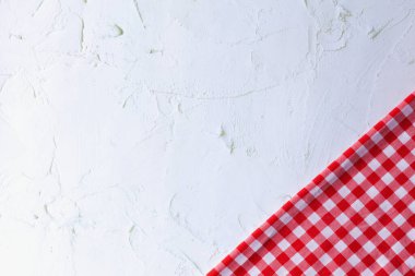 Modern Gri Yüzeyde Kırmızı ve Beyaz Pamuk Kumaş. Kırmızı gingham ve gri beton arka planda fotokopi alanı var. Beton, kırmızı ve beyaz pamuk kumaş arasındaki farklılık.