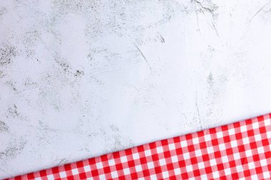 Modern Gri Yüzeyde Kırmızı ve Beyaz Pamuk Kumaş. Kırmızı gingham ve gri beton arka planda fotokopi alanı var. Beton, kırmızı ve beyaz pamuk kumaş arasındaki farklılık.