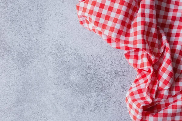 Gingham Deseni ve Kopyalama Uzayı ile Kırsal Piknik Arkaplanı. Kırmızı kareli kumaş, alttaki sağ köşede katlanmış, açık gri yüzeyde. Negatif alan metin ya da ürün için mükemmeldir.