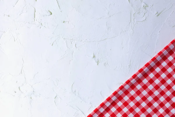 Modern Gri Yüzeyde Kırmızı ve Beyaz Pamuk Kumaş. Kırmızı gingham ve gri beton arka planda fotokopi alanı var. Beton, kırmızı ve beyaz pamuk kumaş arasındaki farklılık.