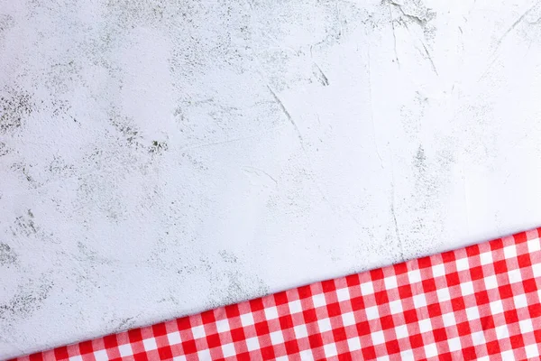 Modern Gri Yüzeyde Kırmızı ve Beyaz Pamuk Kumaş. Kırmızı gingham ve gri beton arka planda fotokopi alanı var. Beton, kırmızı ve beyaz pamuk kumaş arasındaki farklılık.