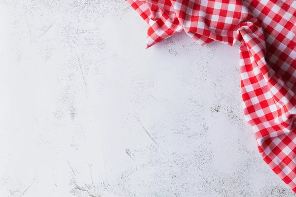 Kopya alanı olan bir arkaplan. Concrete 'deki Red Gingham' ın tepesinde. Beton zemin ya da masa üzerinde gelişigüzel duran kırmızı bir bez parçasının üst görünümü. Kopyalama alanı olan arkaplan.