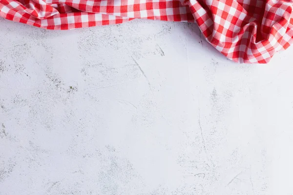 Beton 'daki Red Gingham' ın yukarıdan görünüşü. Beton zemin ya da masa üzerinde gelişigüzel duran kırmızı bir bez parçasının üst görünümü. Kopyalama alanı olan arkaplan.